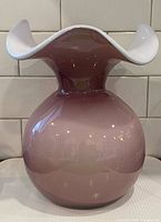 Front view showing pink cased glass vase with white ruffled rim