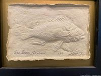 Front view showing paper cast sea bass in frame, artist signature