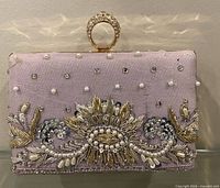 Front view of lavender embroidered clutch with mandala motif and pearl accents