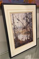 Oblique view of framed print showing mat, glazing, and frame edge