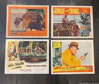 Front view of all four lobby cards showing film titles and artwork