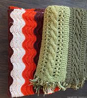 Folded green cable-pattern and ripple-stripe blankets side by side