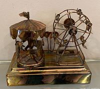 Front view of music box showing carousel and Ferris wheel figures on base