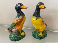 Front angled view of both ceramic mallard duck shakers