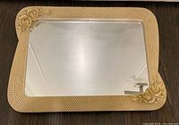 Front view of rectangular mirror with ornate pearl-beaded frame and rose decorations