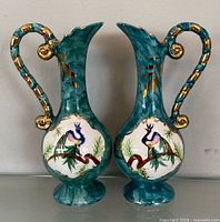 Front view of both teal ceramic vases with peacock panels