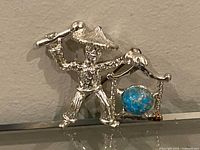 Front view showing figure, gong frame and blue cabochon