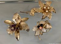 Front view of all three brooches showing design, enamel colours and bead centres