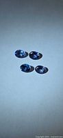 Four oval tanzanite gemstones on neutral background