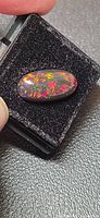 Front view of loose Ethiopian black opal showing multicolour play