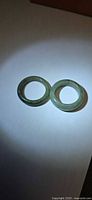 Two green jade band rings side-by-side on white background