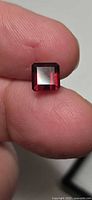 Square emerald cut rubelite showing face-up deep red color
