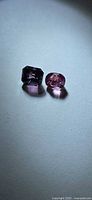 Purple rectangular and pink oval spinels side by side
