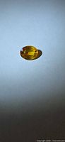 Top view of oval yellow-orange sapphire on neutral background
