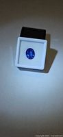 Oval blue gemstone in white display box