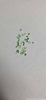 Group of small green round faceted stones on white background