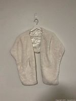 Front view of ivory-white fur shoulder shawl on hanger