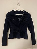 Front view of Guess dark wash denim jacket on hanger showing overall condition and style