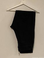 Folded dark grey trousers on hanger