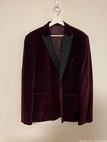 Full front view of burgundy velvet blazer on hanger