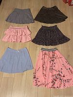 All six skirts laid out flat showing colours and styles
