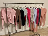 Full rack of eleven assorted tops on hangers