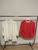 Overall view of both blazers on rack: white and red