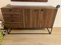 Front view of sideboard showing drawers, doors, metal base