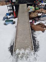 Full view of aluminum ramp set from snow up to truck deck