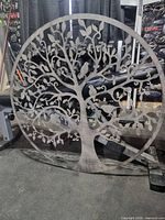 Full view of circular metal wall art with tree design