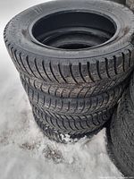 Stack of four winter tires in snow