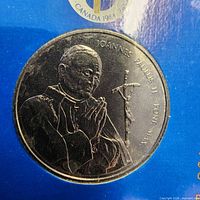 Obverse of commemorative coin showing portrait and inscriptions in blue presentation card