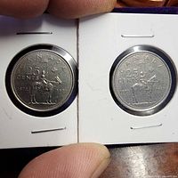 Both 25-cent RCMP Centennial coins in flips, reverse side showing mounted officer