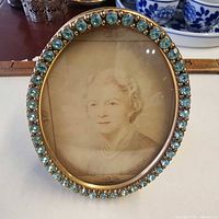 Front view of oval frame with aqua stones and portrait