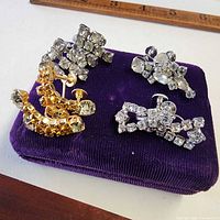 Overview showing three pairs of rhinestone screw back earrings on purple pad