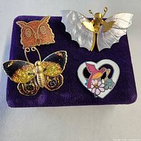 Four brooches arranged on purple display pad