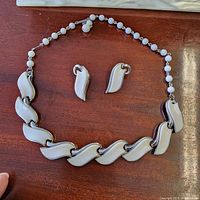 Necklace laid in semicircle with earrings centered