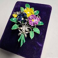 Front view showing multicolour enamel flowers, leaves, bow design