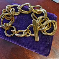 Bracelet on cushion showing chain links and signed tag