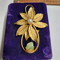 Front view showing pearl center and jade cabochon, ruler for scale