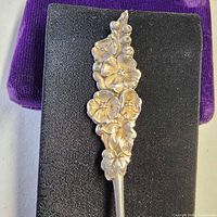 Close-up of ornate floral and berry handle detailing