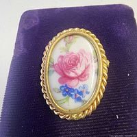 Front view showing floral porcelain cabochon and gold-tone frame