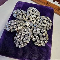 Front view of rhinestone flower brooch on purple pad