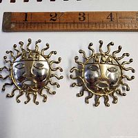 Front view of both sun face earrings with ruler showing size