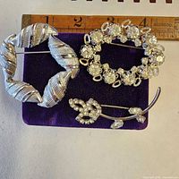 all three brooches with ruler for scale