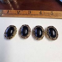 four button covers on white background with ruler showing size