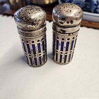 Front view of both shakers showing openwork sleeves and domed tops