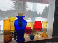 Group shot of all eight colored art glass pieces on window sill