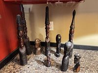 Group shot of all eleven carved wooden African sculptures in varying heights