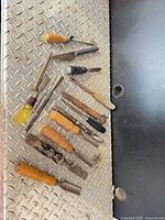 Group of chisels, files and punches on diamond plate surface